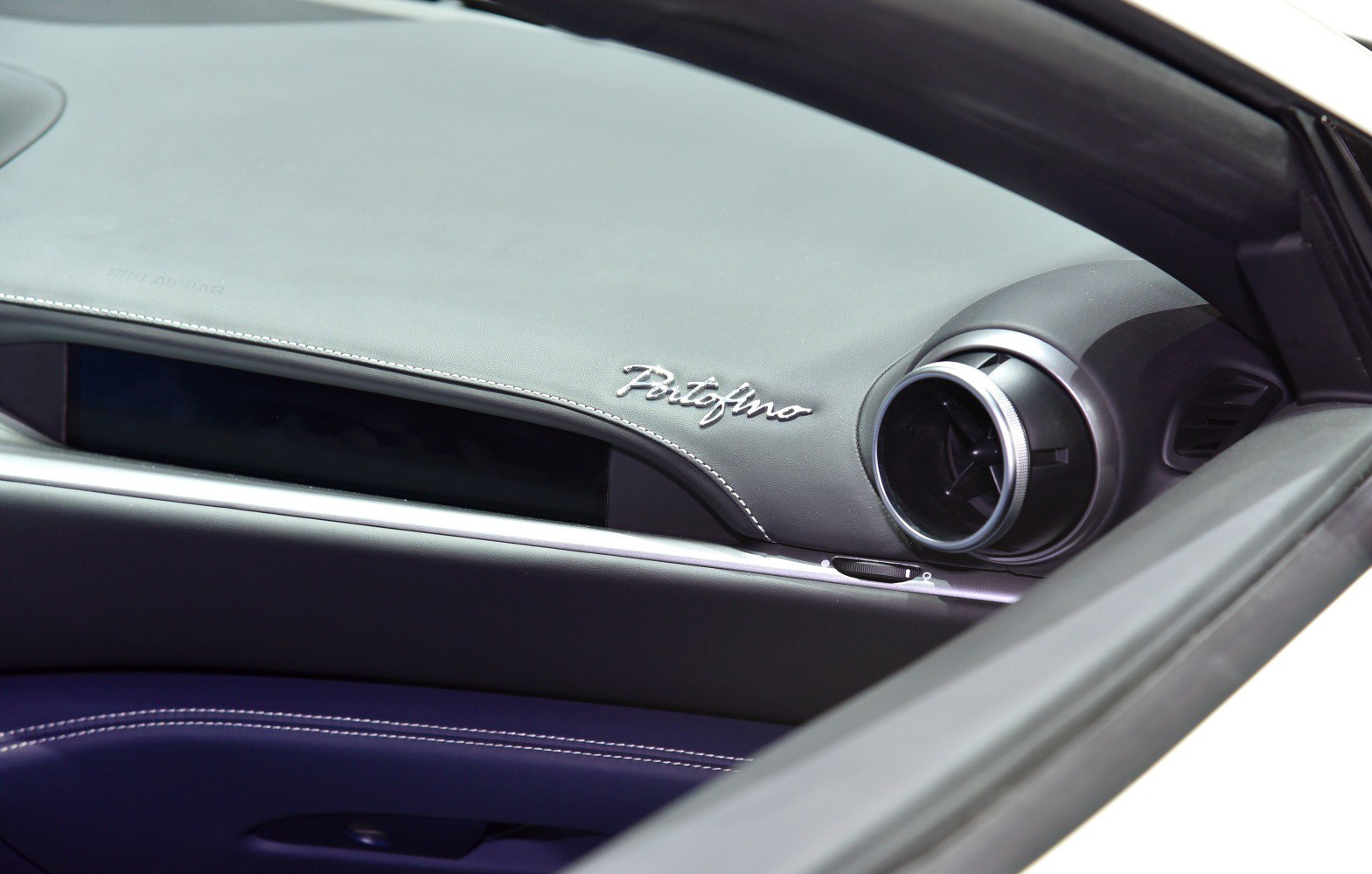 Stitched leather dashboard with circular air vent
