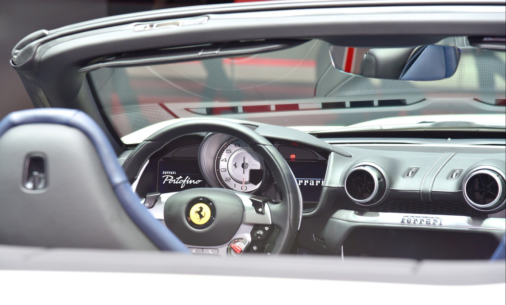 Dashboard and steering wheel with tachometer in luxury convertible.