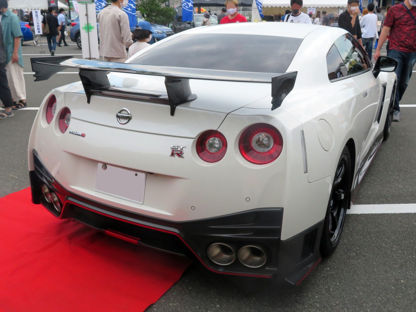 Rear view of white sports car with quad exhaust and large rear spoiler