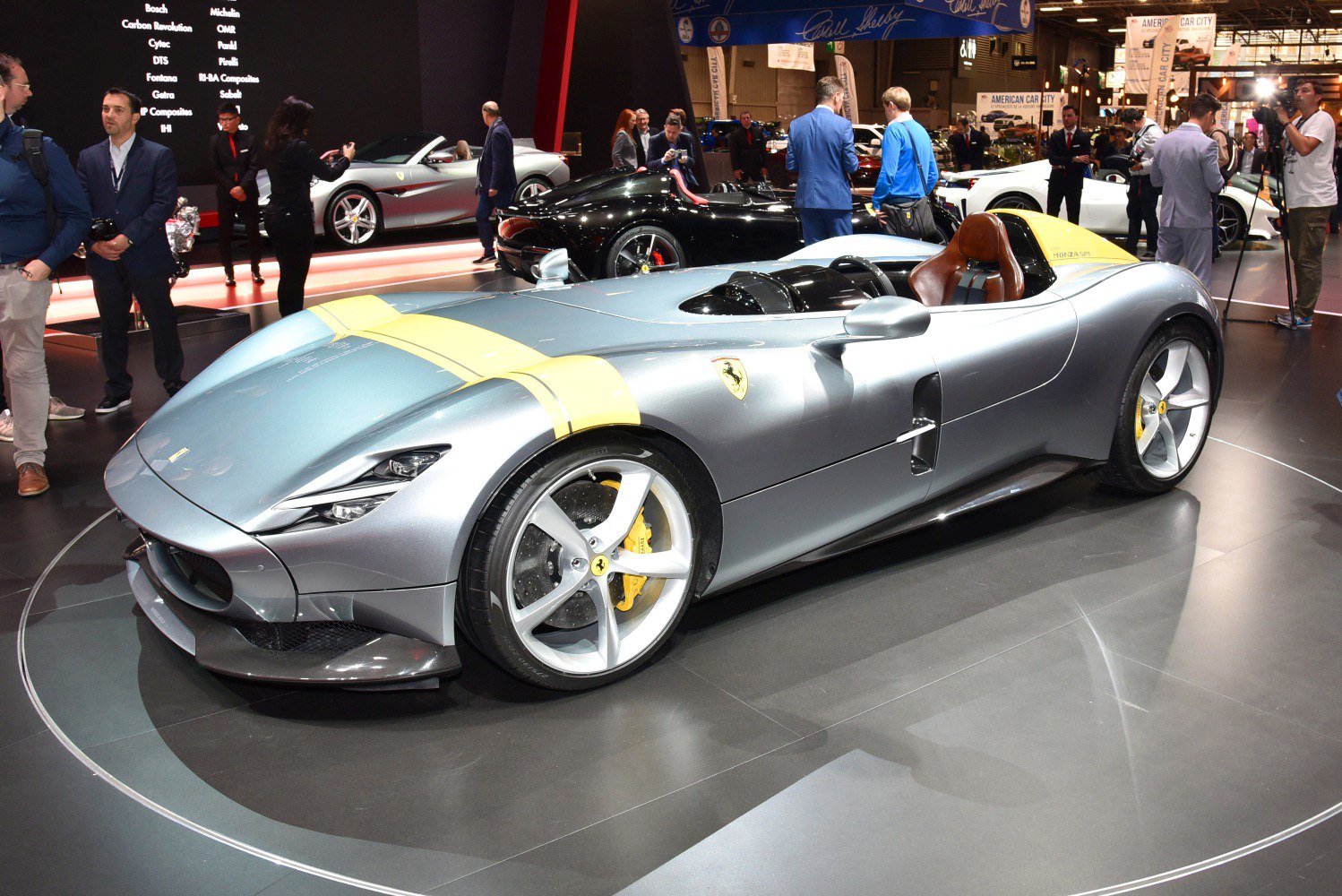 Silver roadster with single-seat cockpit and distinctive yellow racing stripe