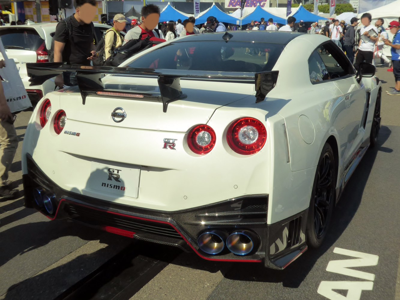 Rear view with quad exhausts, large carbon fiber wing, and diffuser