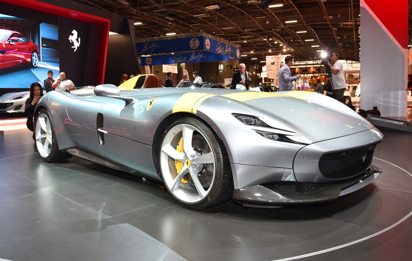 Silver sports car with yellow racing stripes and an open two-seater cockpit.