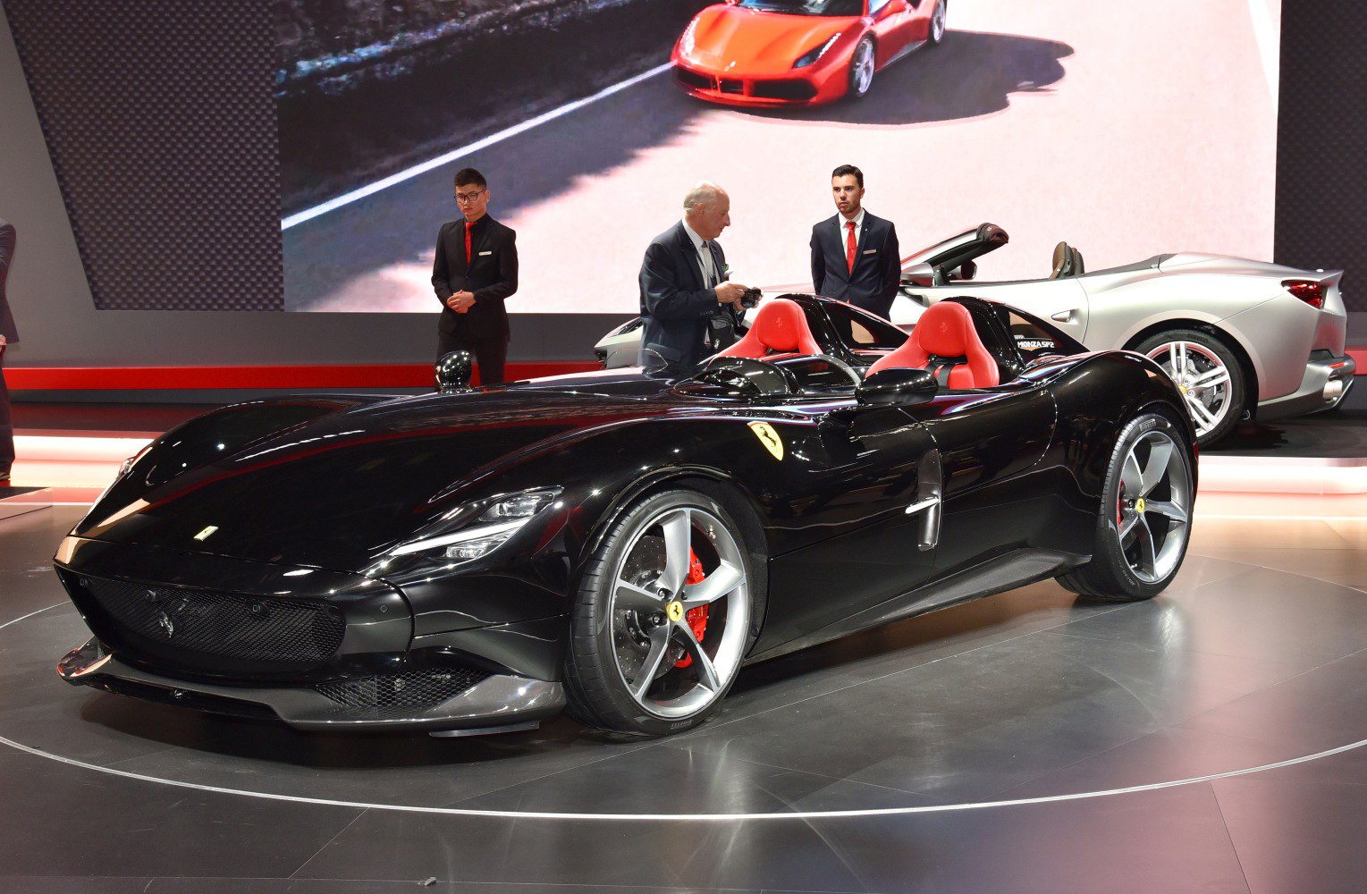 Black open cockpit sports car with red seats and sleek aerodynamic design