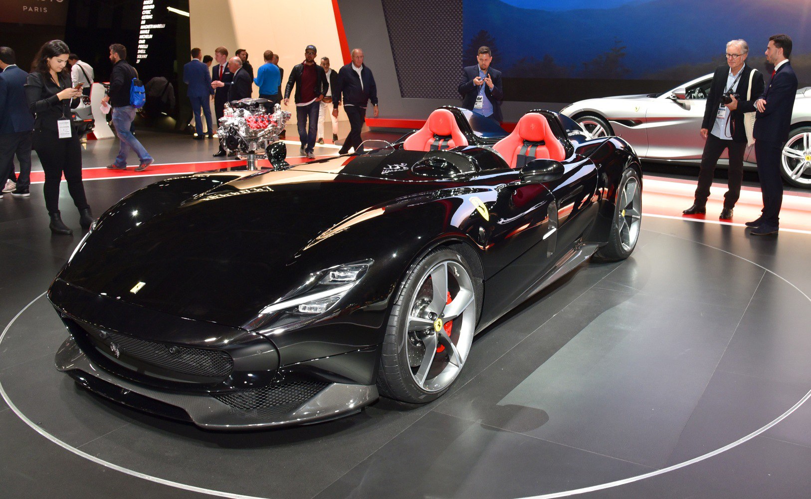 Black aerodynamic roadster with red interior seats and sporty design