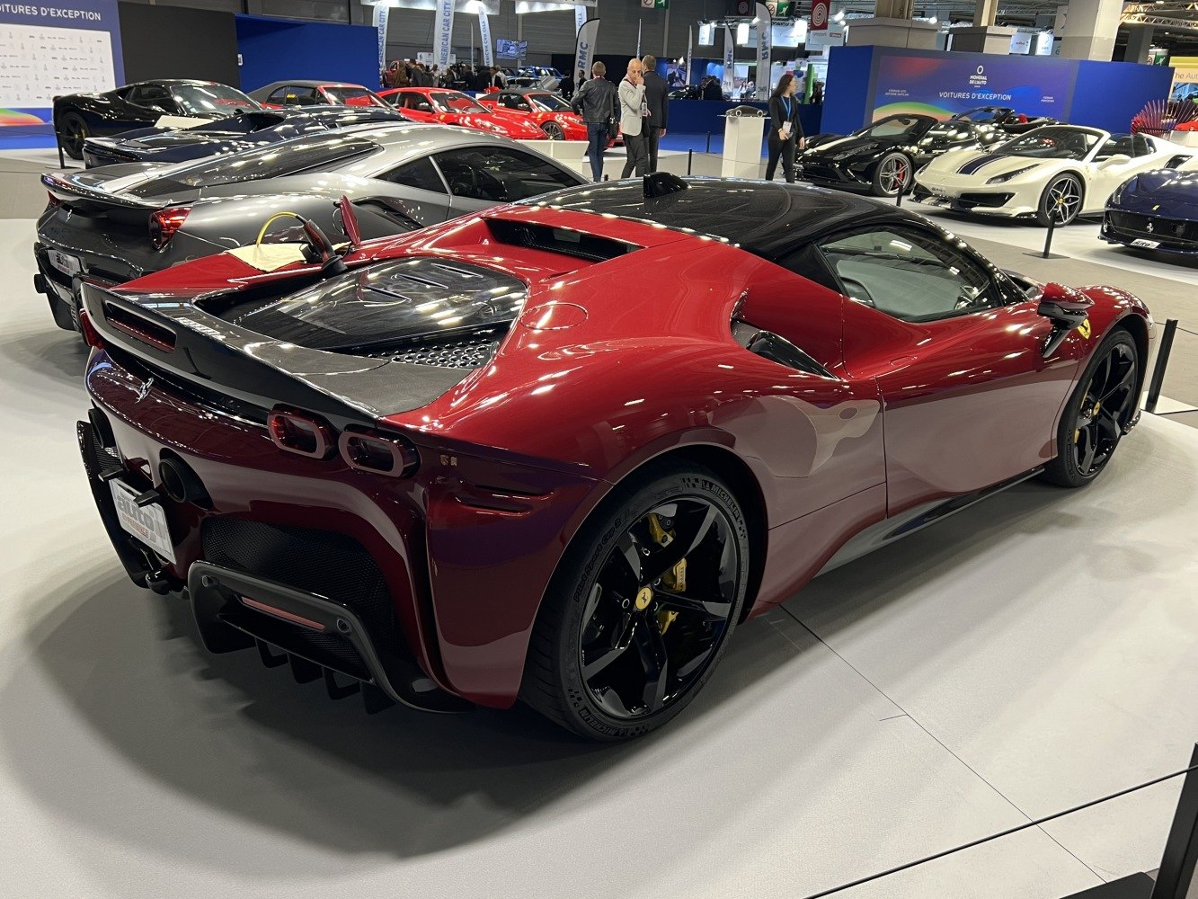 Glossy red Ferrari with black roof and wheels showing rear and side details