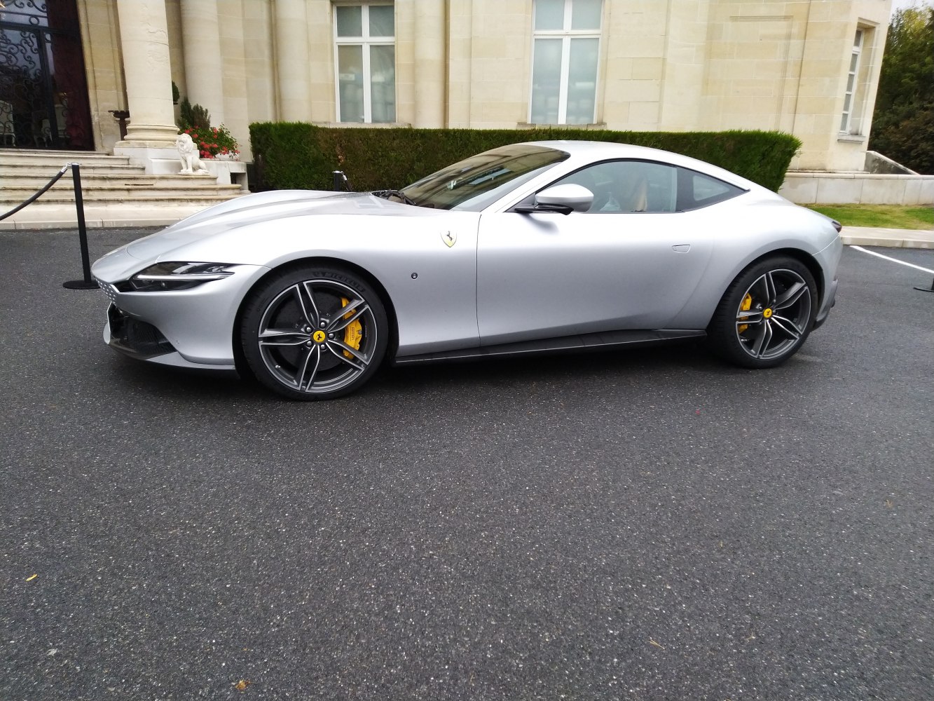 Side profile of silver sports coupe with alloy wheels and yellow calipers