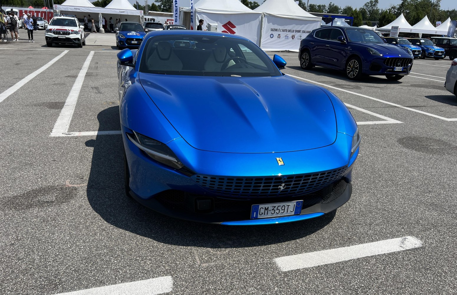 Front view of a blue sports coupe with sculpted hood and distinctive grille
