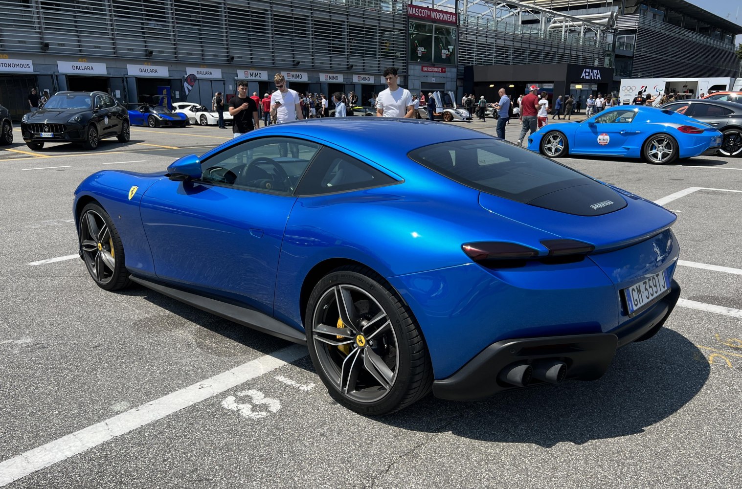 Sleek blue sports coupe rear side with black dual exhaust and alloy wheels