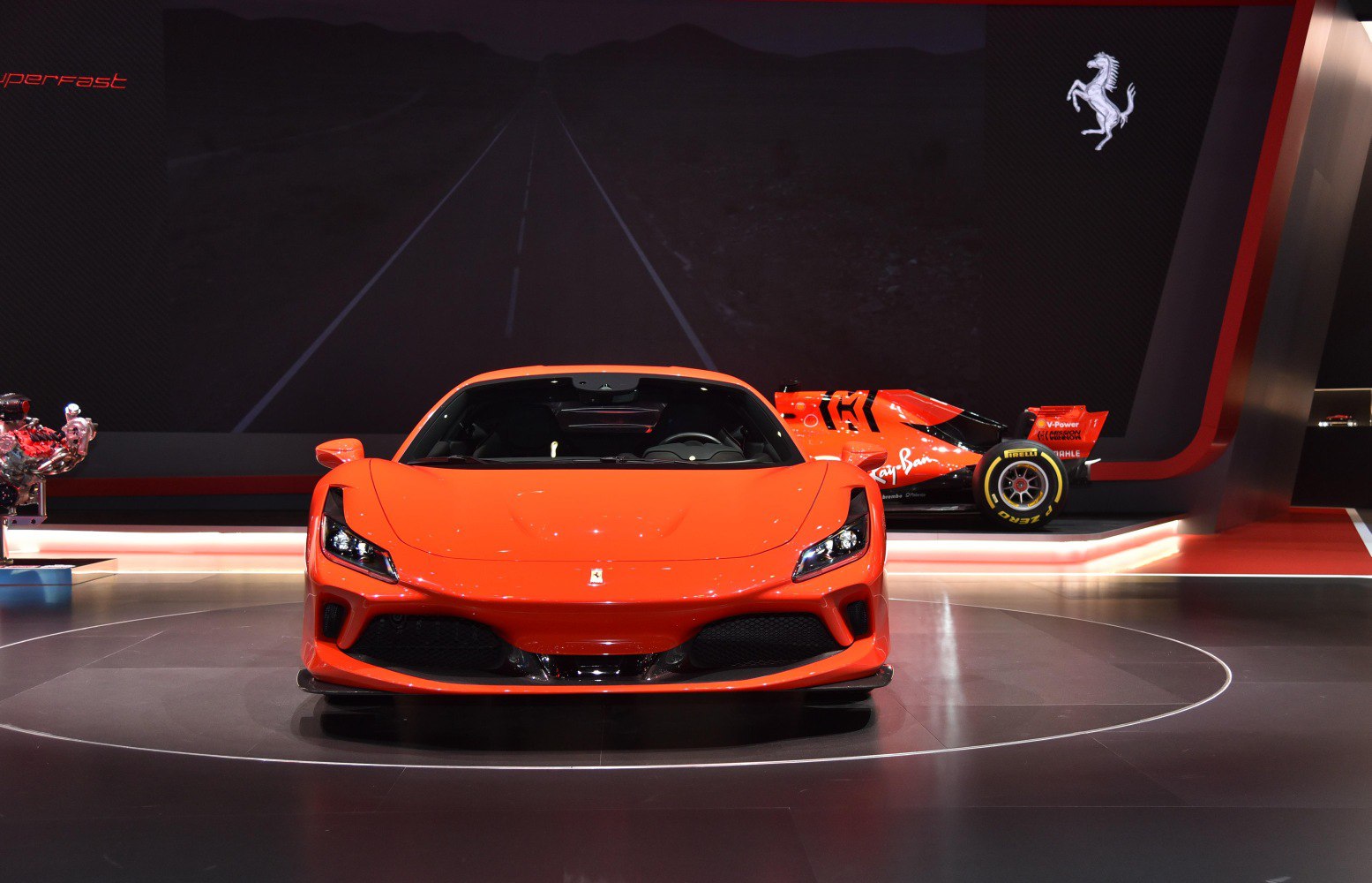 Front view of a bright orange supercar with aggressive aerodynamic styling