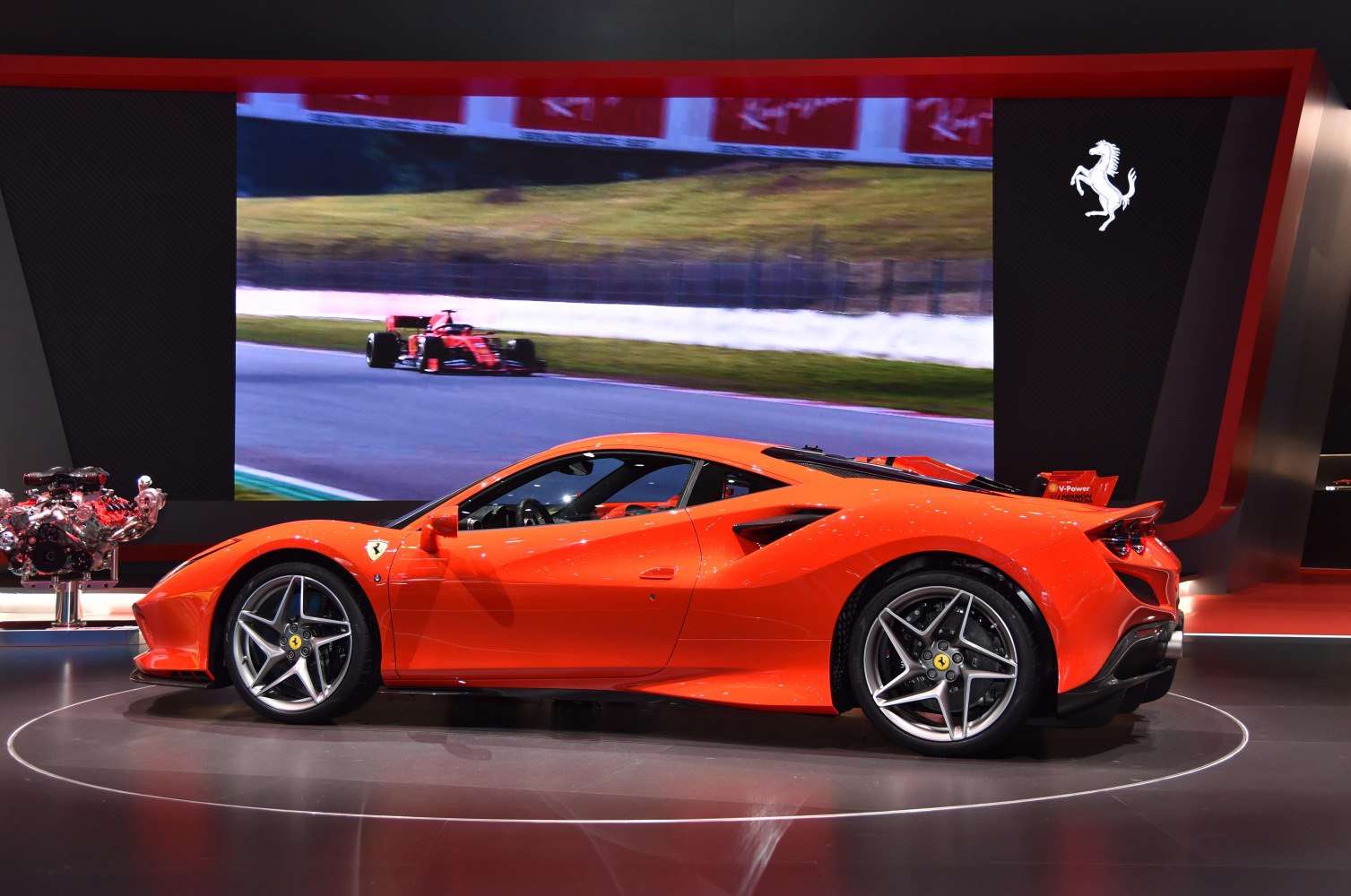 Side profile of a sleek red sports coupe with aerodynamic design and alloy wheels
