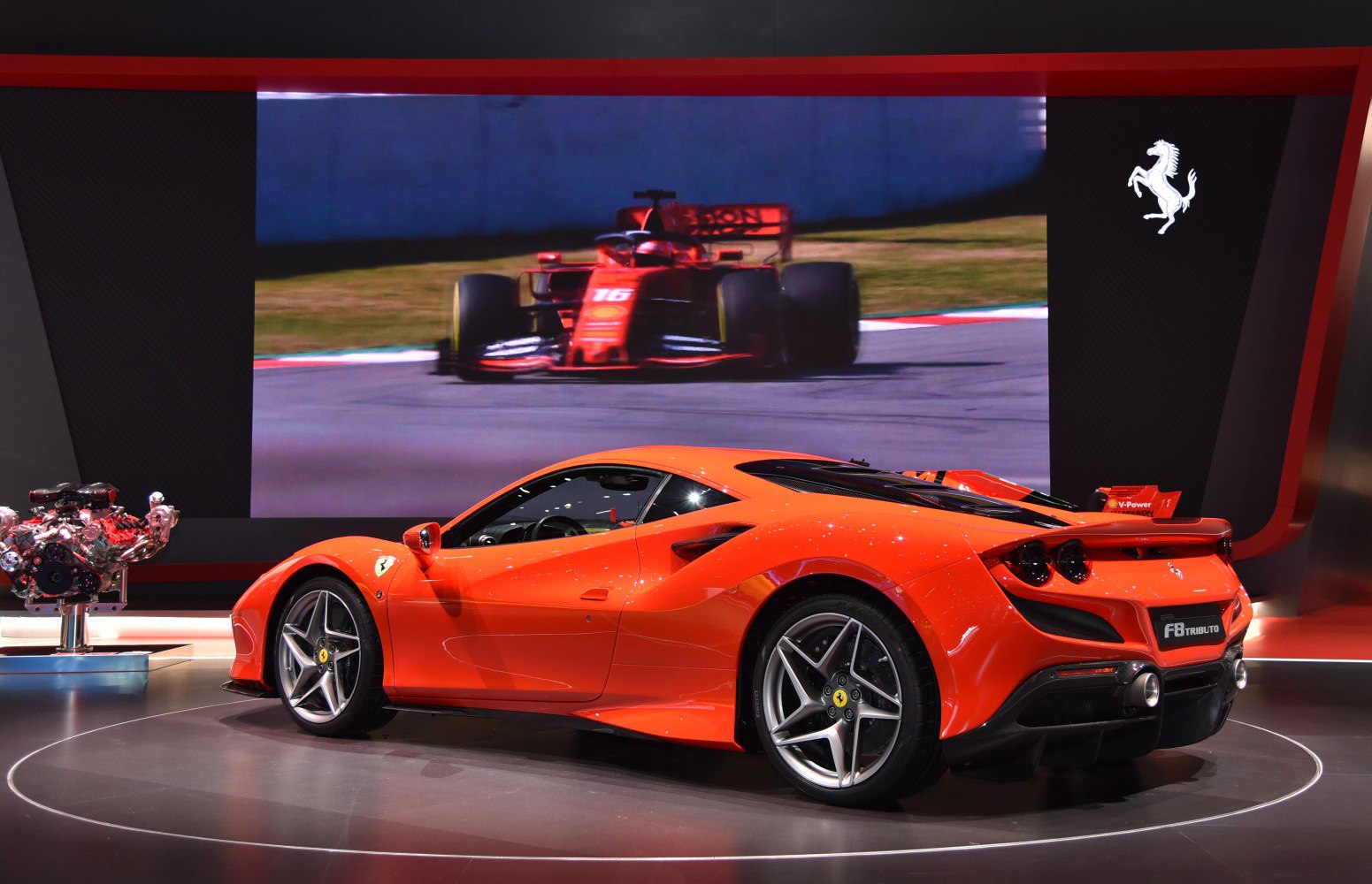 Rear side profile of red sports car with aerodynamic design and alloy wheels.
