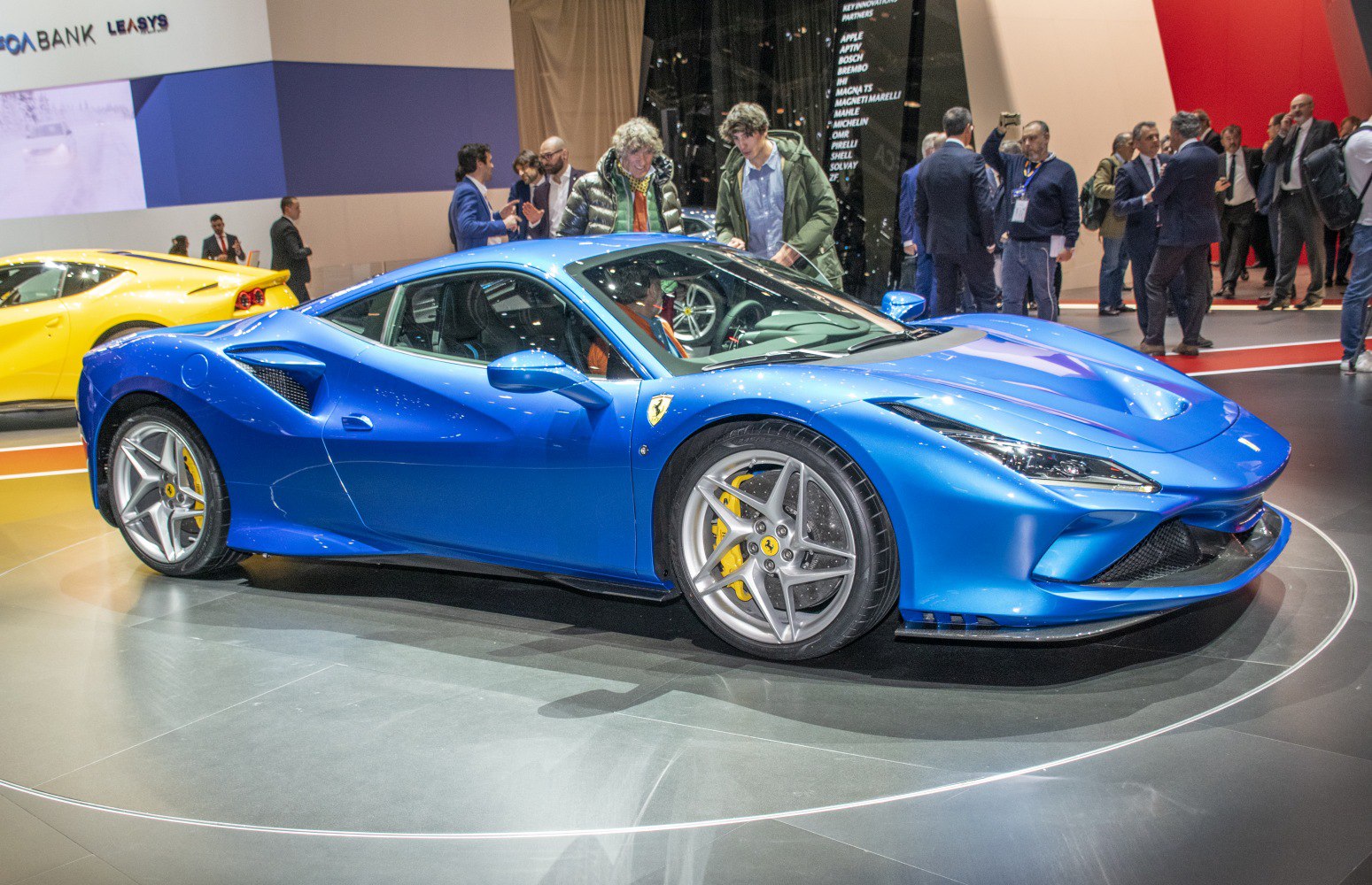 Blue mid-engine sports car with aerodynamic design and alloy wheels