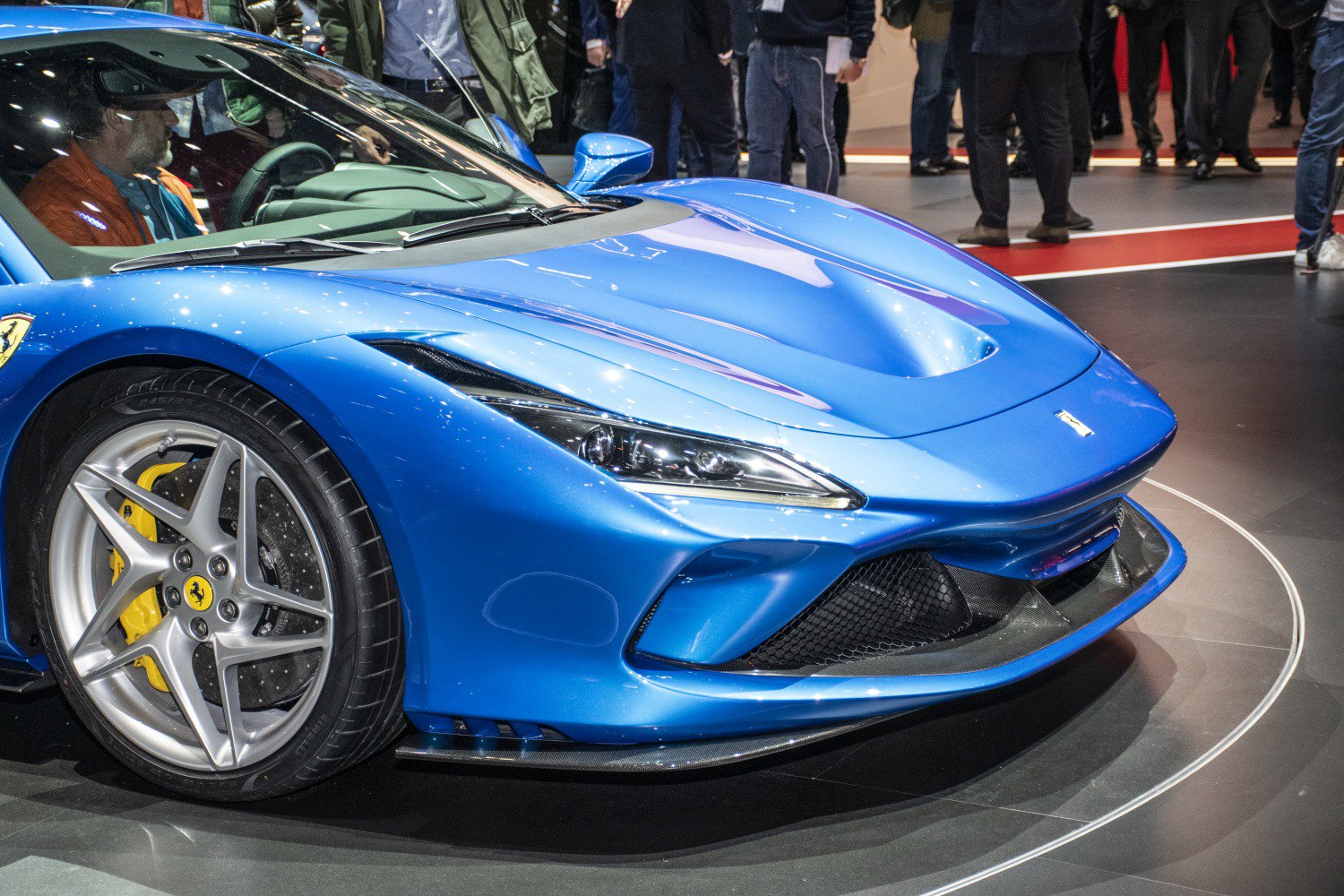 Blue sports car front with sleek headlights and alloy wheels