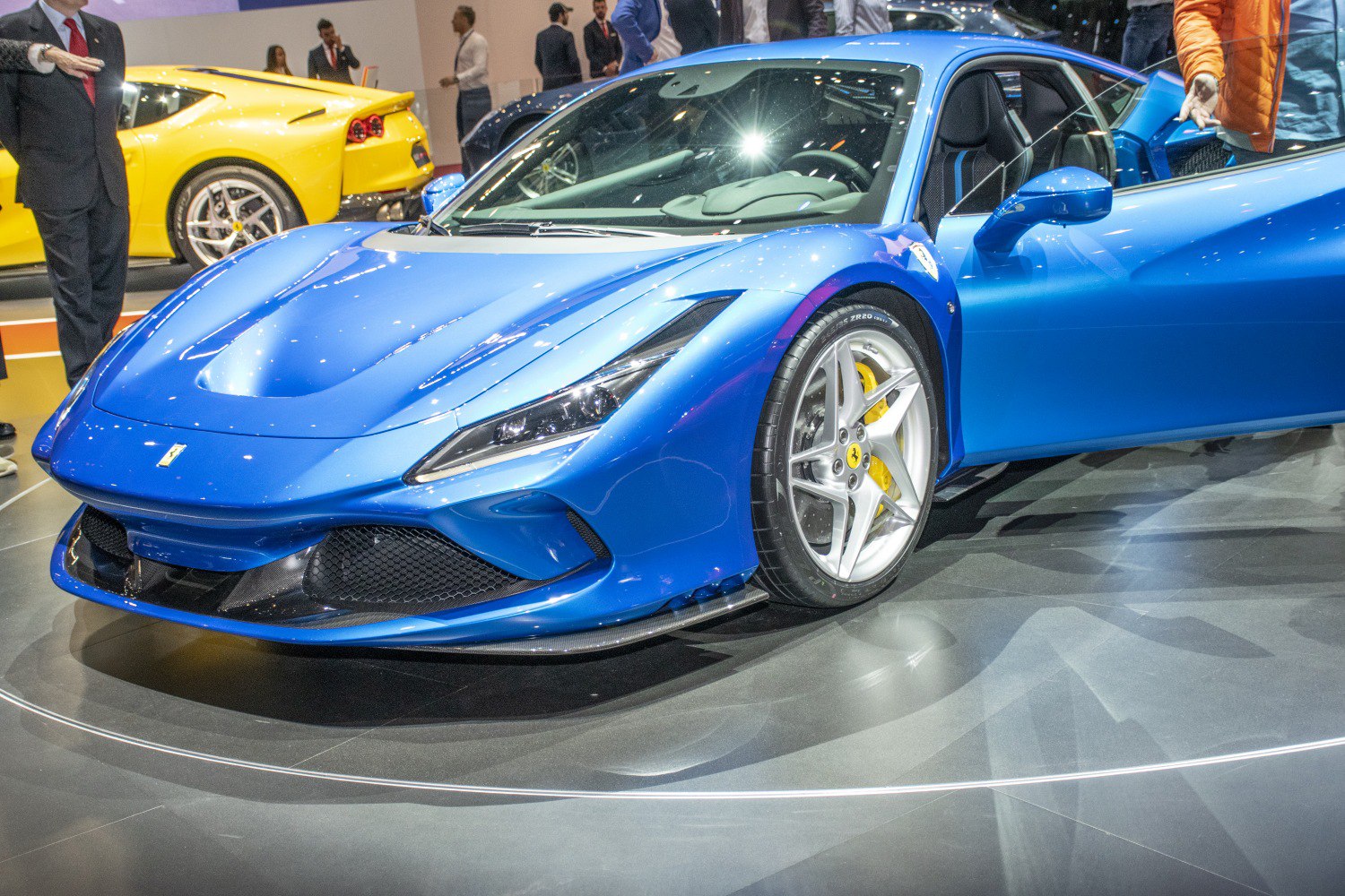 Blue sports car front with open door, sharp headlights, silver alloy wheels
