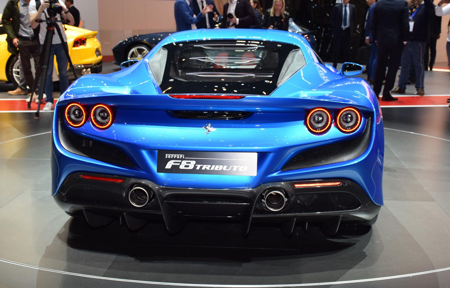 Rear view with quad circular LED taillights and dual exhausts on a blue sports car.