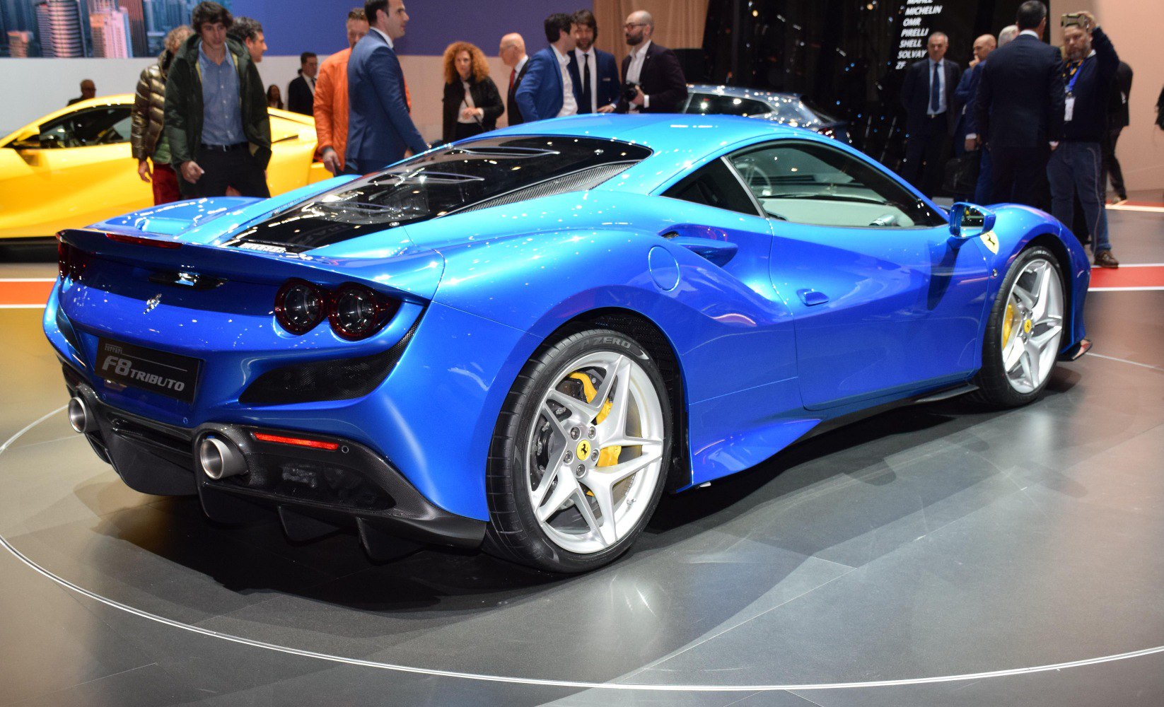 Rear and side view of a blue sports coupe with dual exhaust and aerodynamic lines