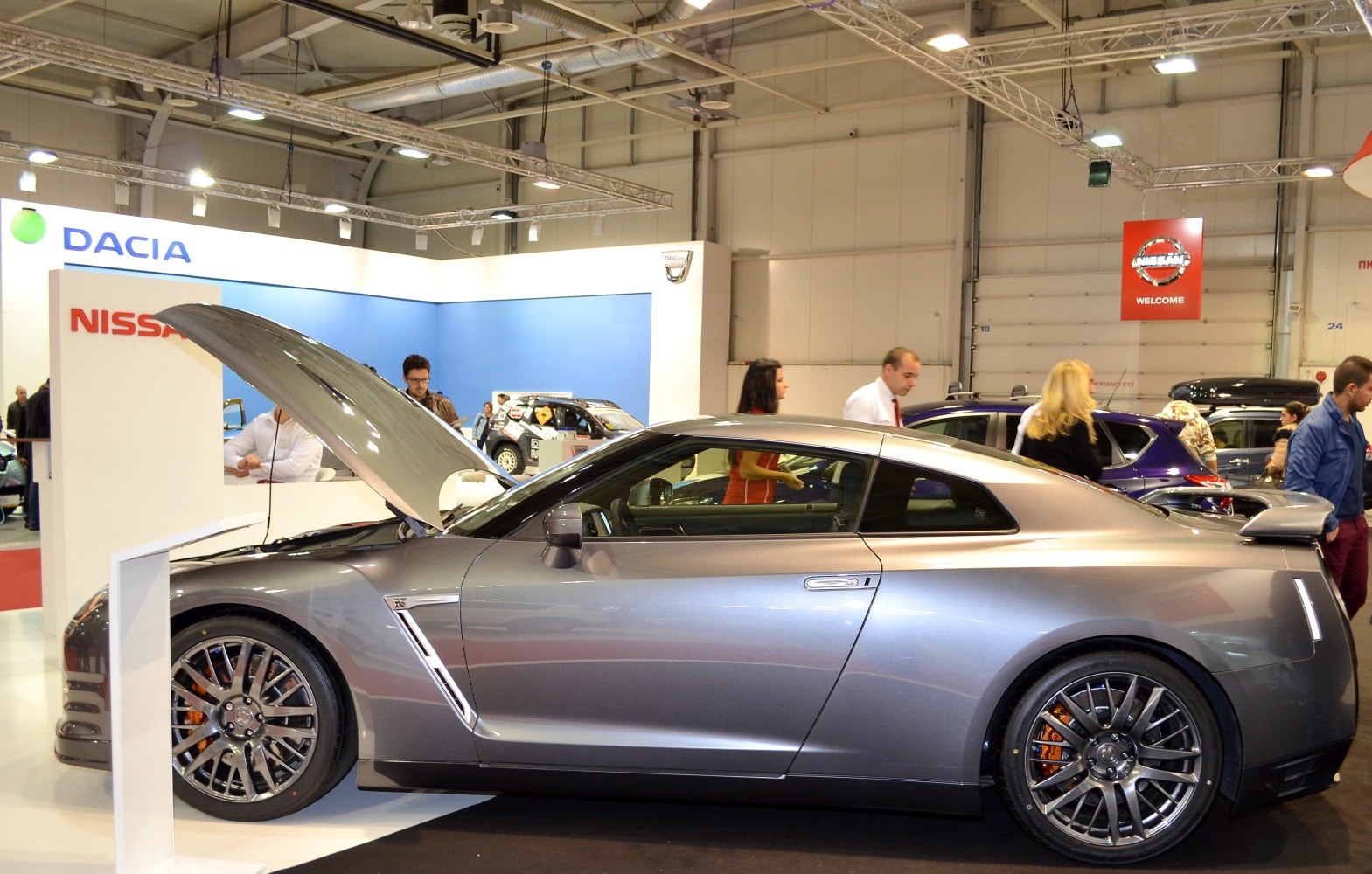 Side view of a sporty coupe with open hood and high-performance alloy wheels