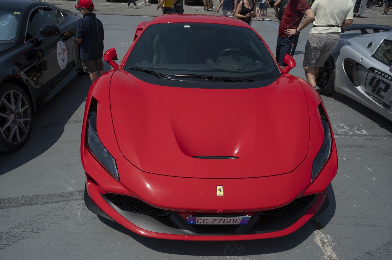 Aerodynamic hood with scoop and sleek LED headlights on red sports car.
