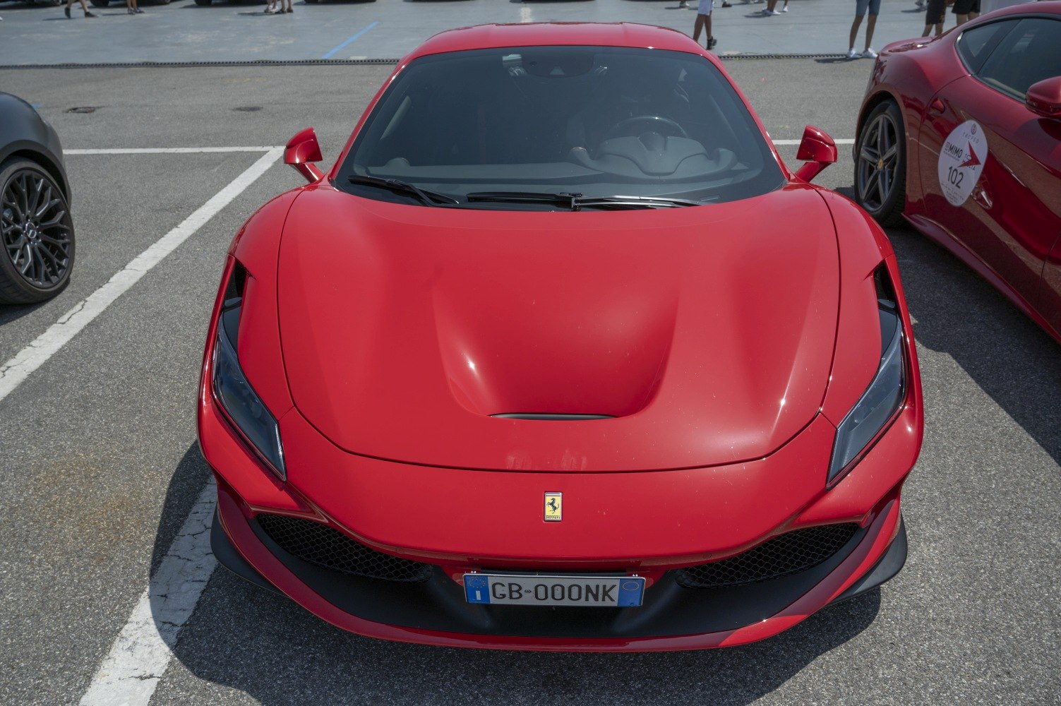 Front view of red sports car with aerodynamic hood and sharp headlights
