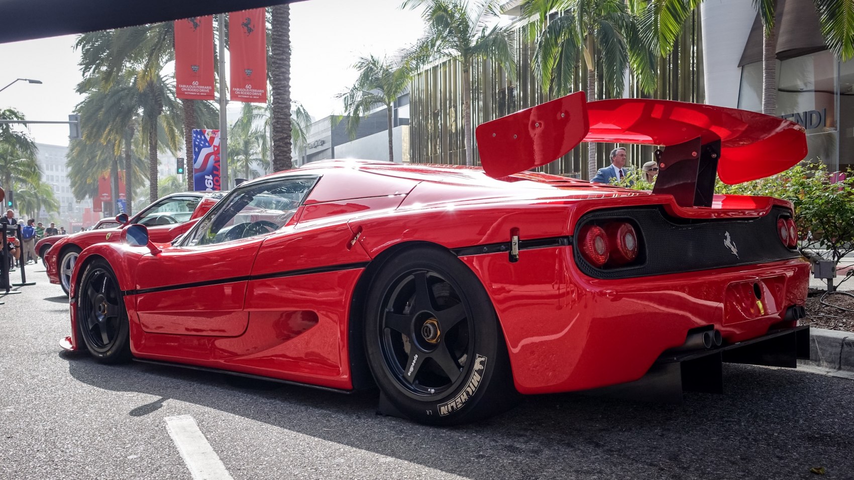 Red racing car rear side view with large wing and black rims
