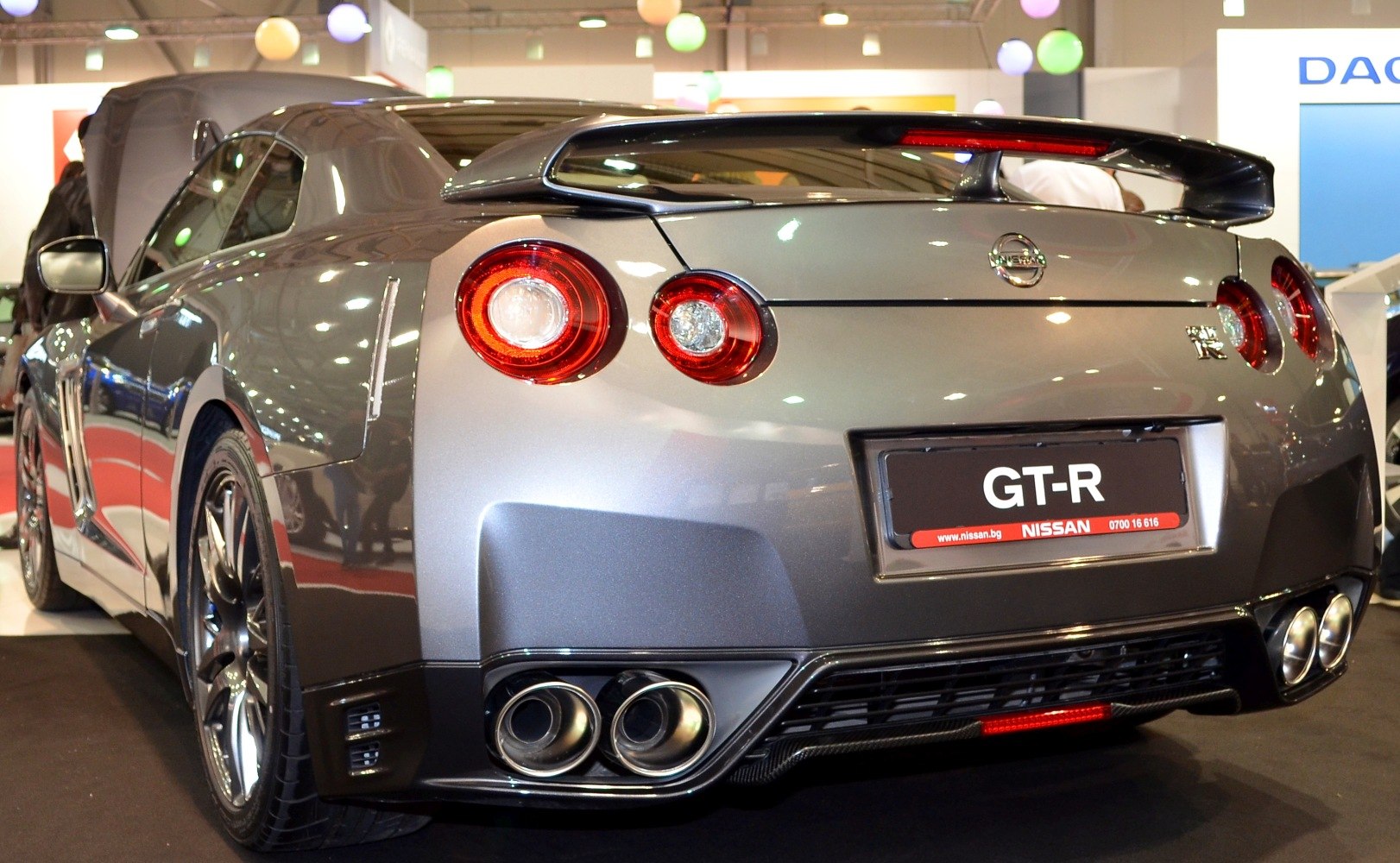 Rear view with round taillights, large spoiler, and quad exhausts