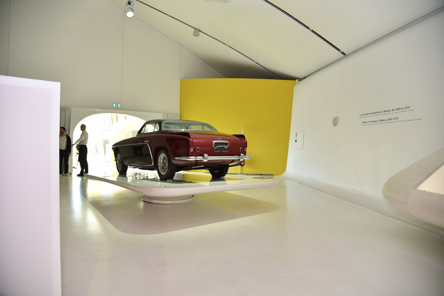 Classic car rear view with chrome bumpers and wire wheels on display platform