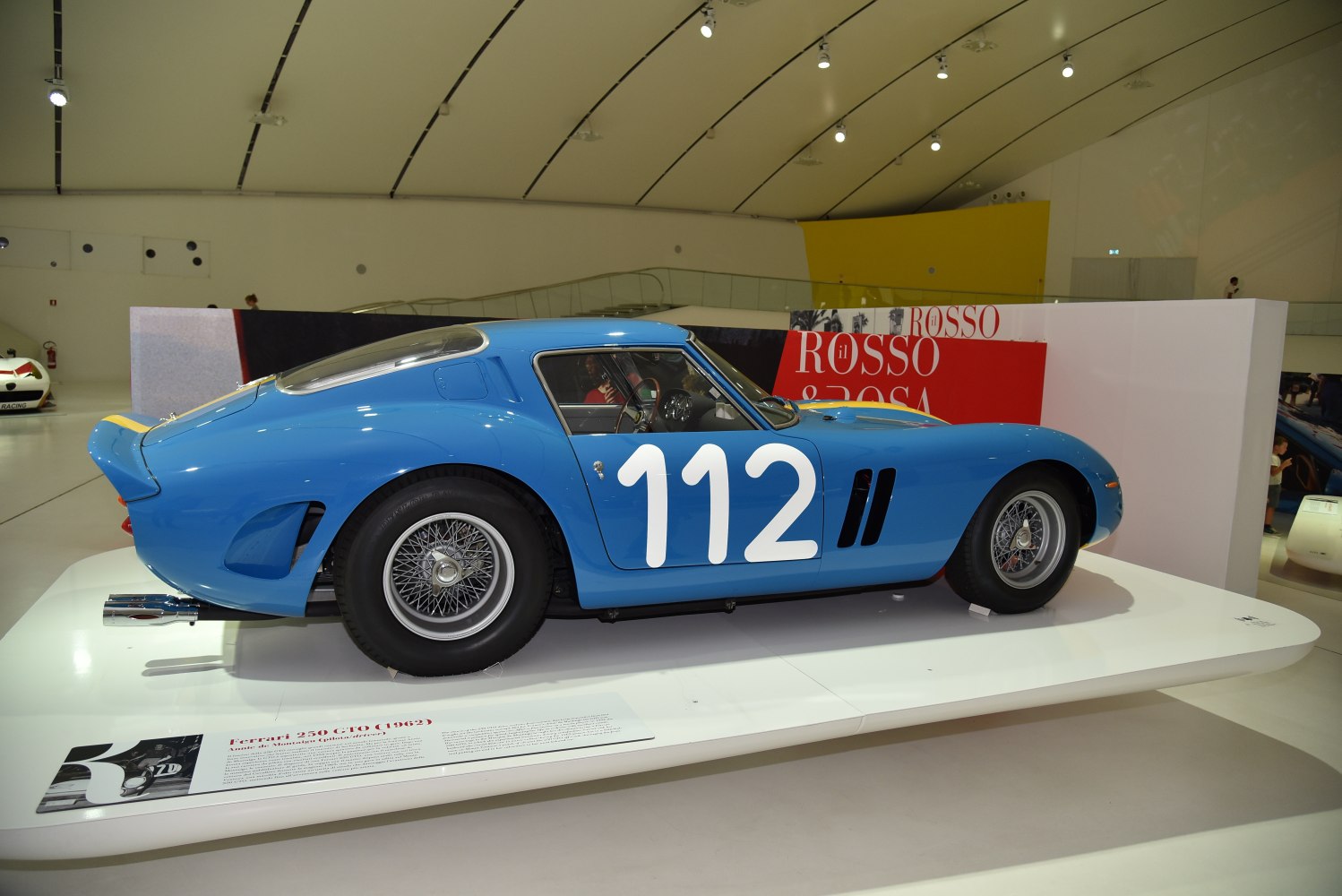 Blue racing coupe with number 112 decal and wire-spoke wheels
