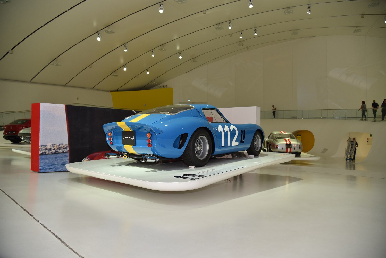 Blue racing car with yellow stripe and number 112