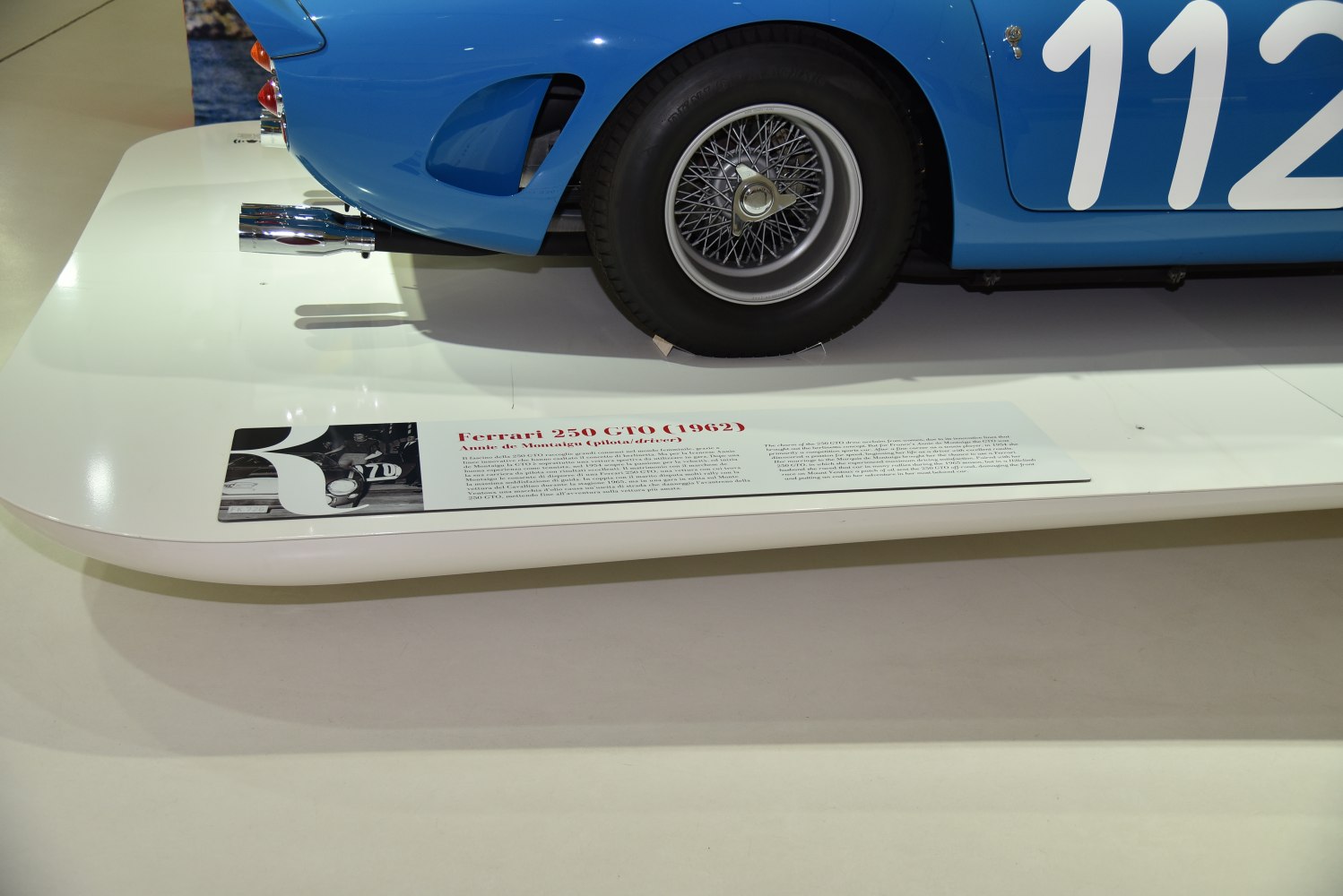 Wire spoke wheel with dual rear exhaust pipes on a vintage racing sports car.