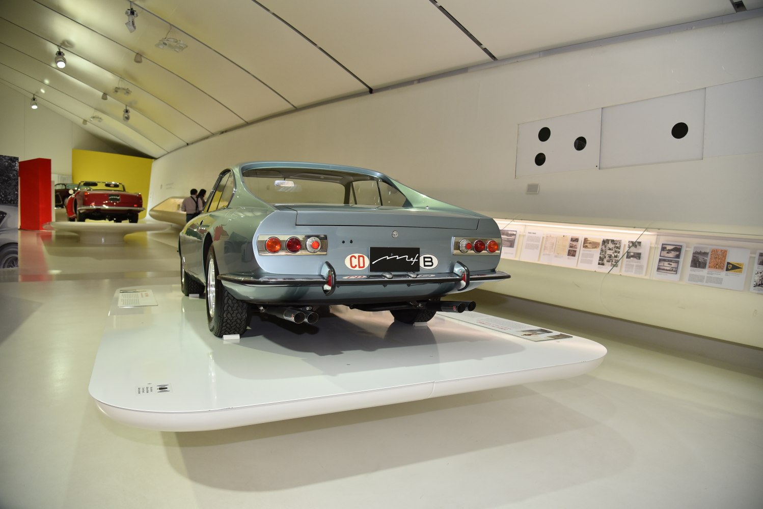 Rear view of a vintage coupe with classic taillights and dual exhaust pipes.