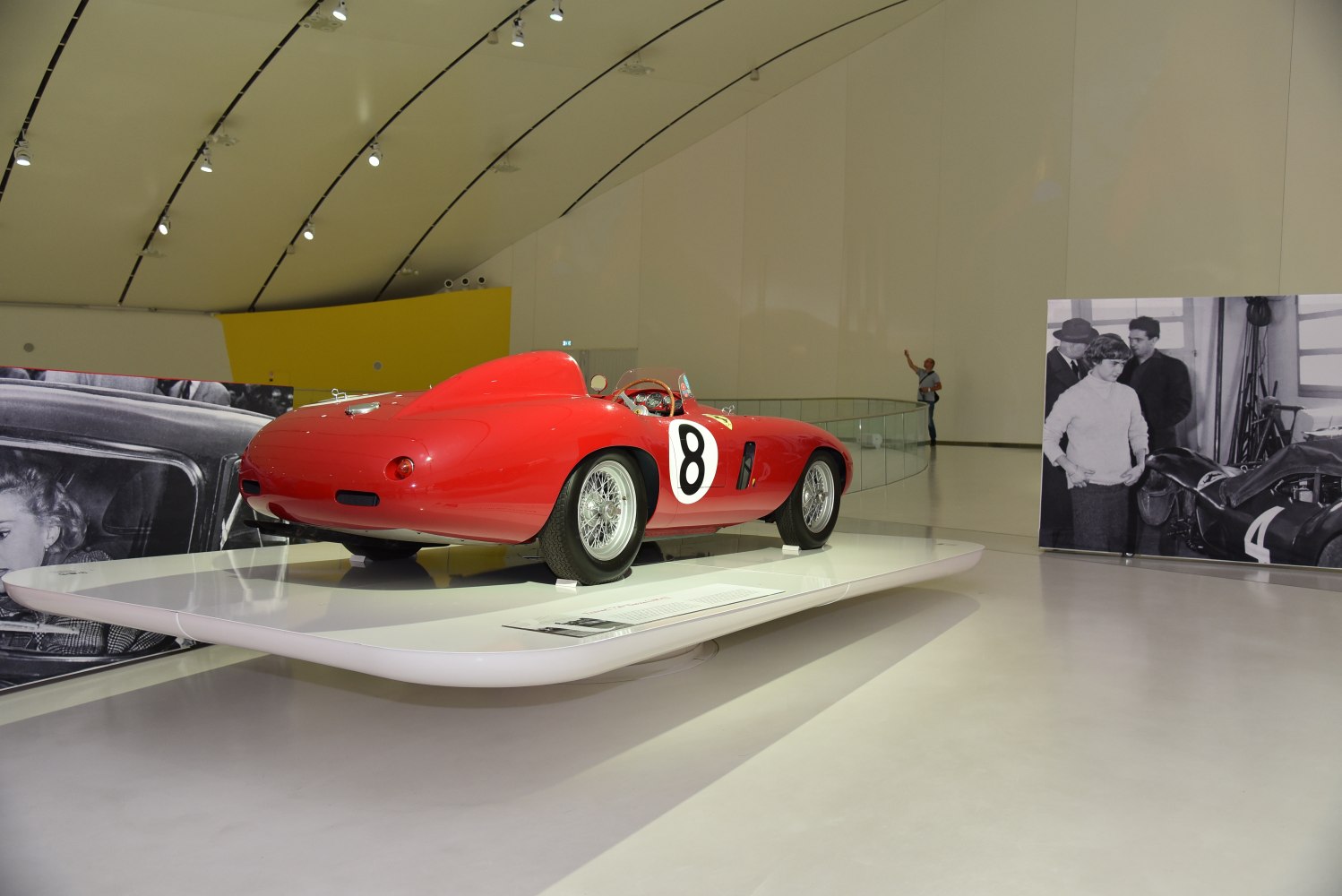 Red vintage racing open-wheel sports car with wire-spoke wheels and number 8