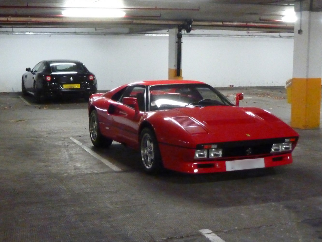 Front view of a classic red vintage sports car with quad headlights