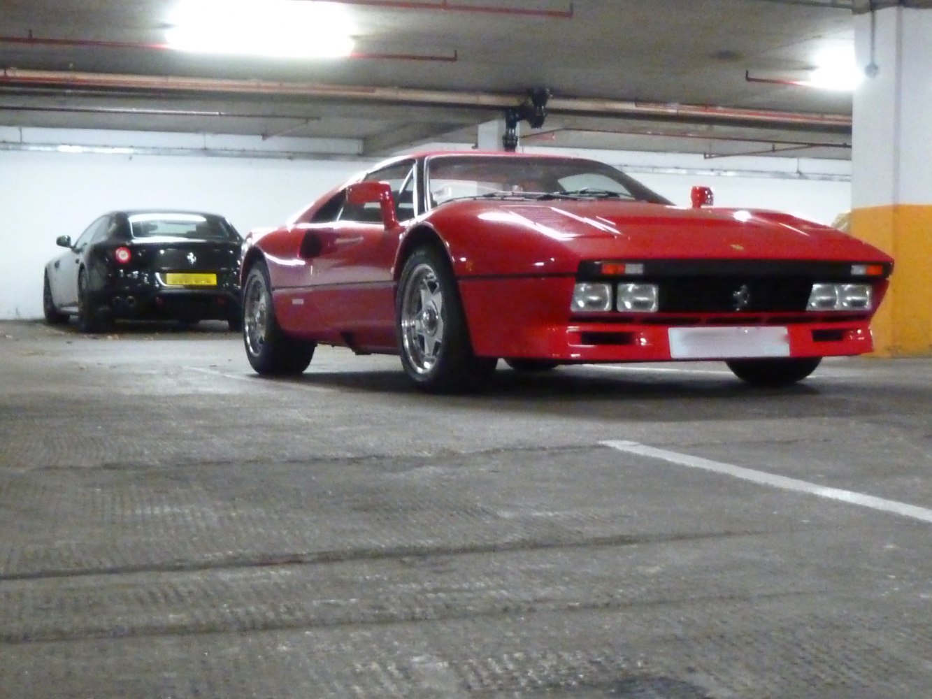 Low-angle front view of red sports car with quad headlights and aerodynamic design