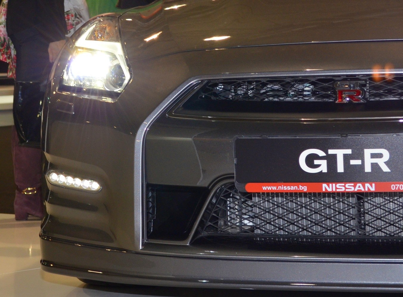 Close-up of front headlight and mesh grille with GT-R badge