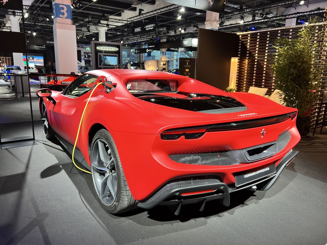 Rear view of matte red sports car plugged in for charging