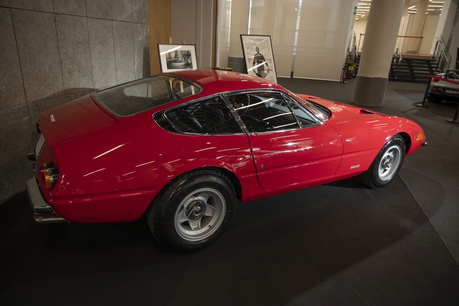 Side and rear profile of a classic red vintage sports coupe.