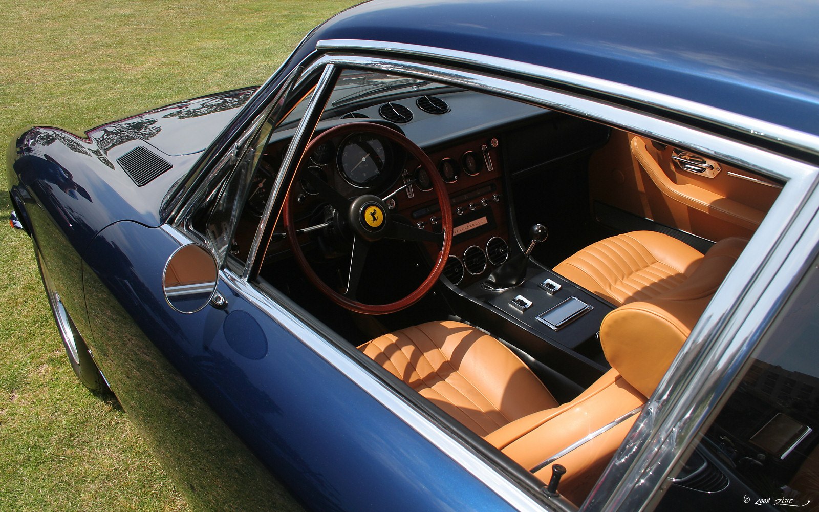 Vintage car interior with wooden steering wheel and tan leather seats