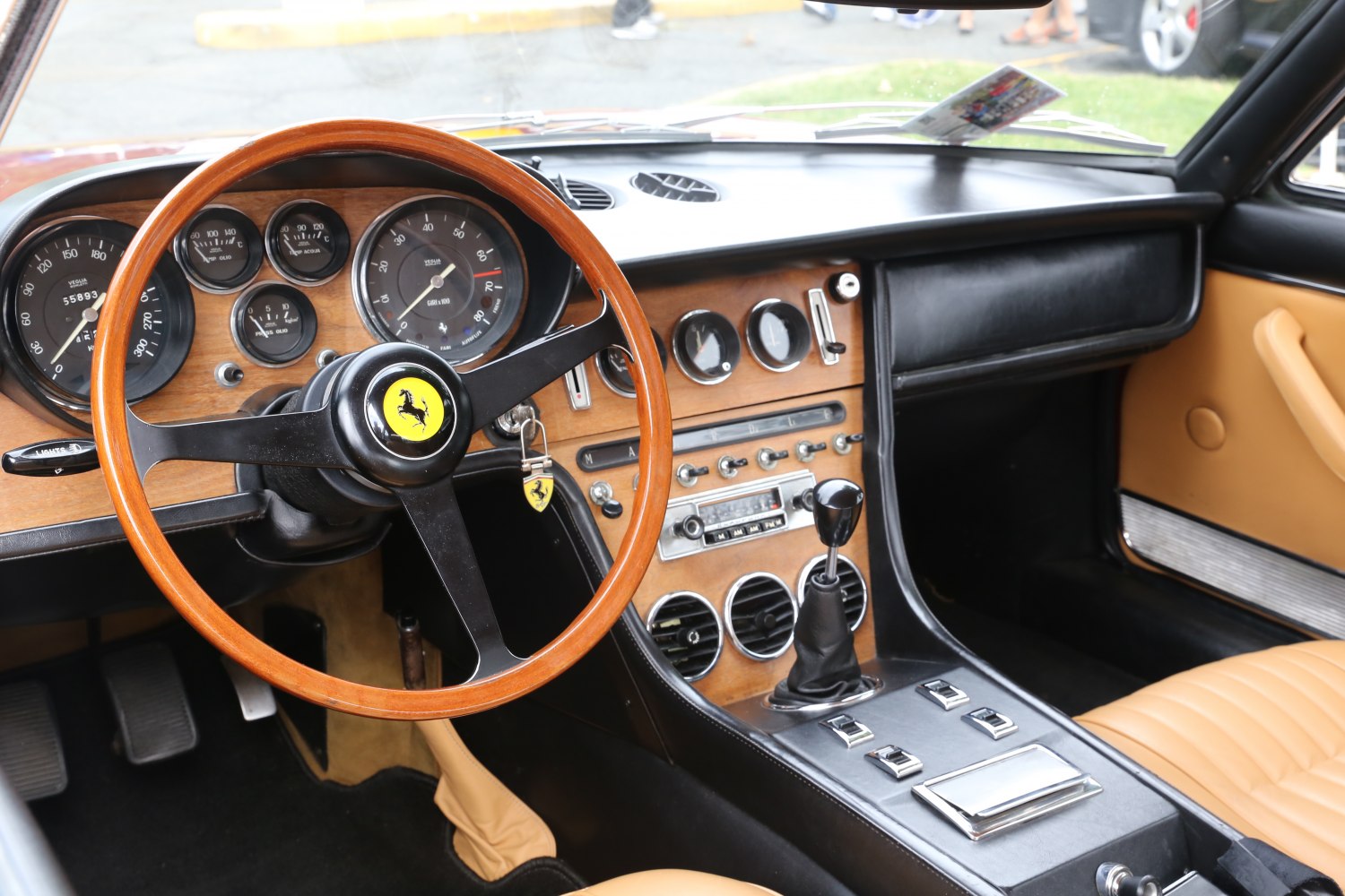 Wooden steering wheel and vintage dashboard with analog gauges and manual gear lever