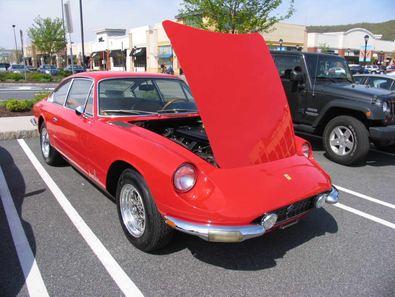 Red classic coupe with hood open front, round headlights, chrome details