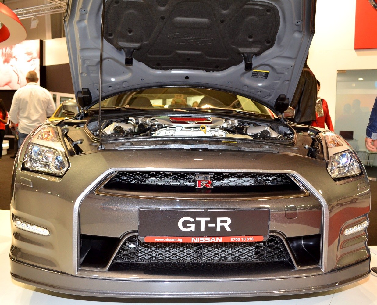 Front view of Nissan GT-R with open hood showing engine and grille