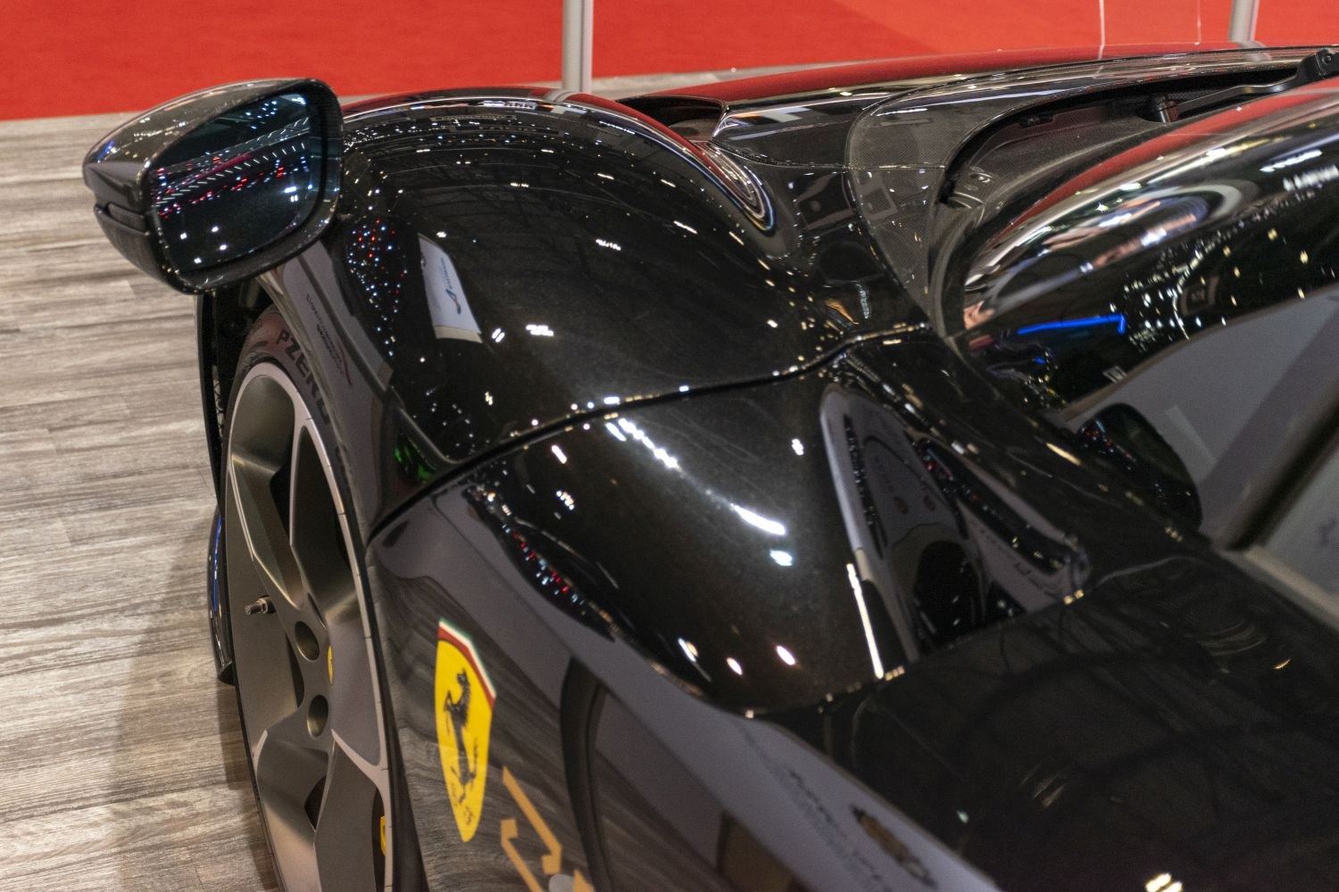 Close-up of side mirror and rear fender with glossy black finish and aerodynamic design