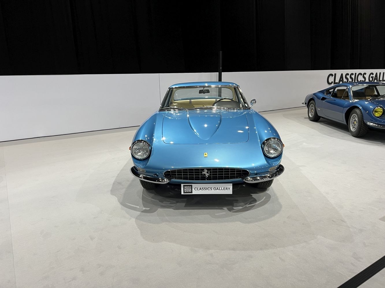 Front view of blue vintage sports car with round headlights and iconic grille