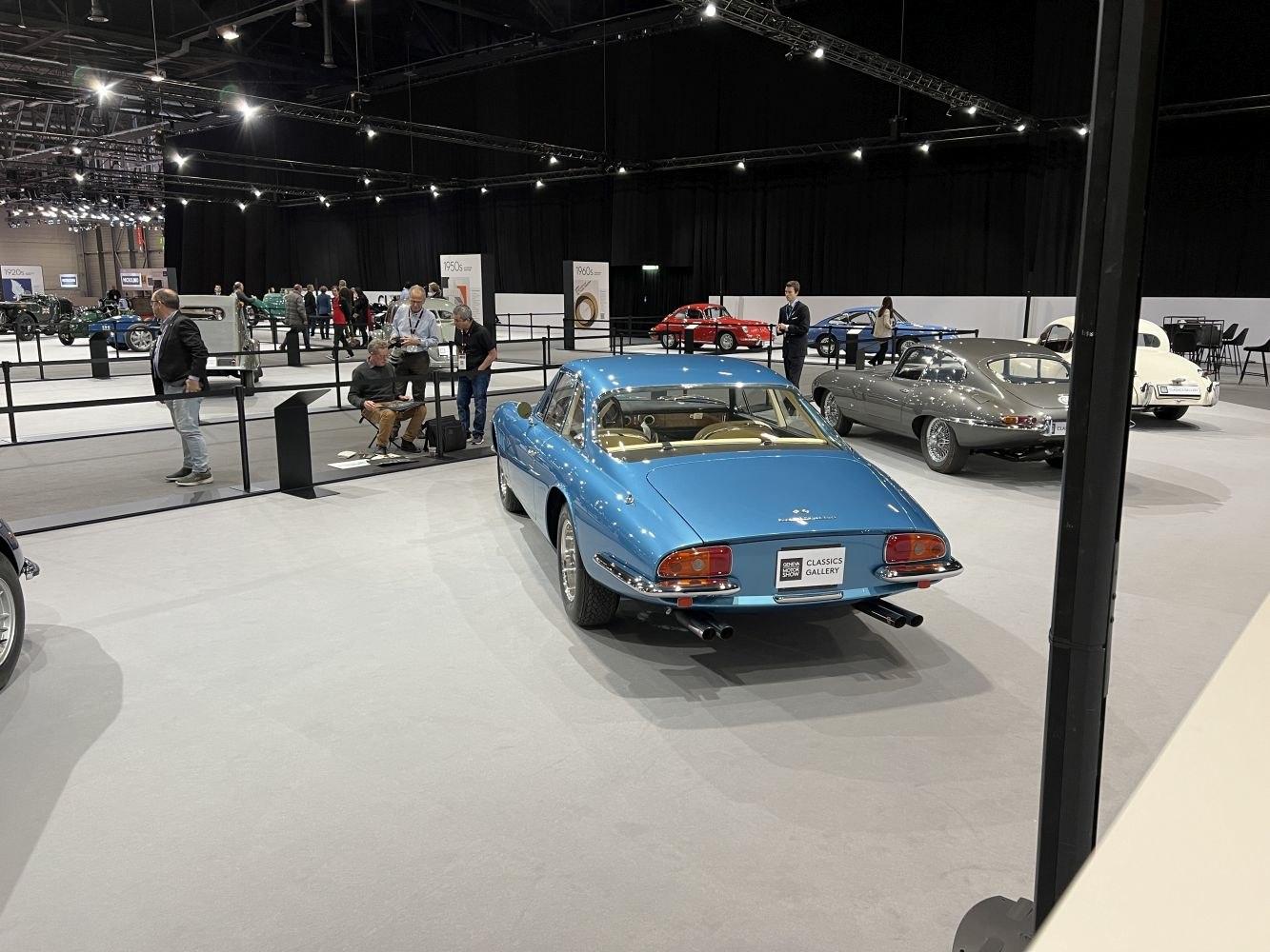 Rear view of blue classic coupe with dual exhaust and large rear windshield