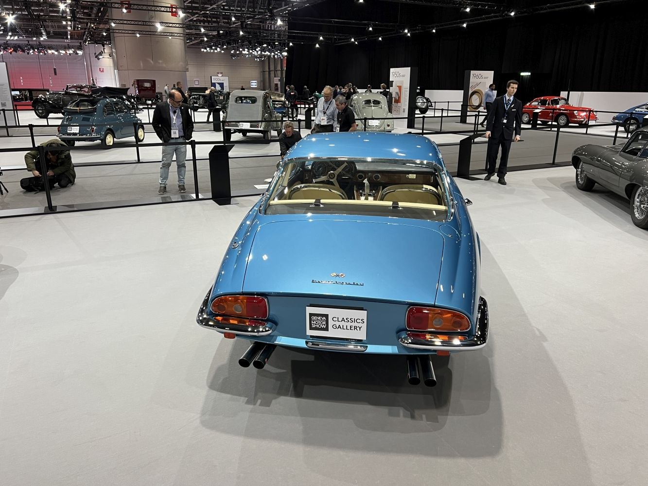 Rear view of vintage coupe with quad exhausts and classic taillights.