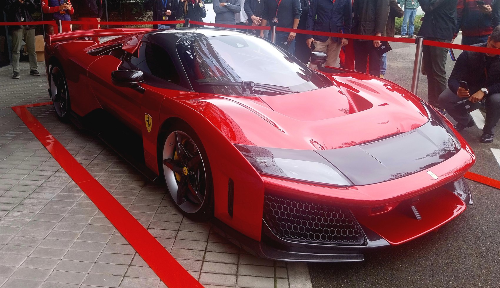 Front view of red sports car with sharp aerodynamic design and honeycomb grille