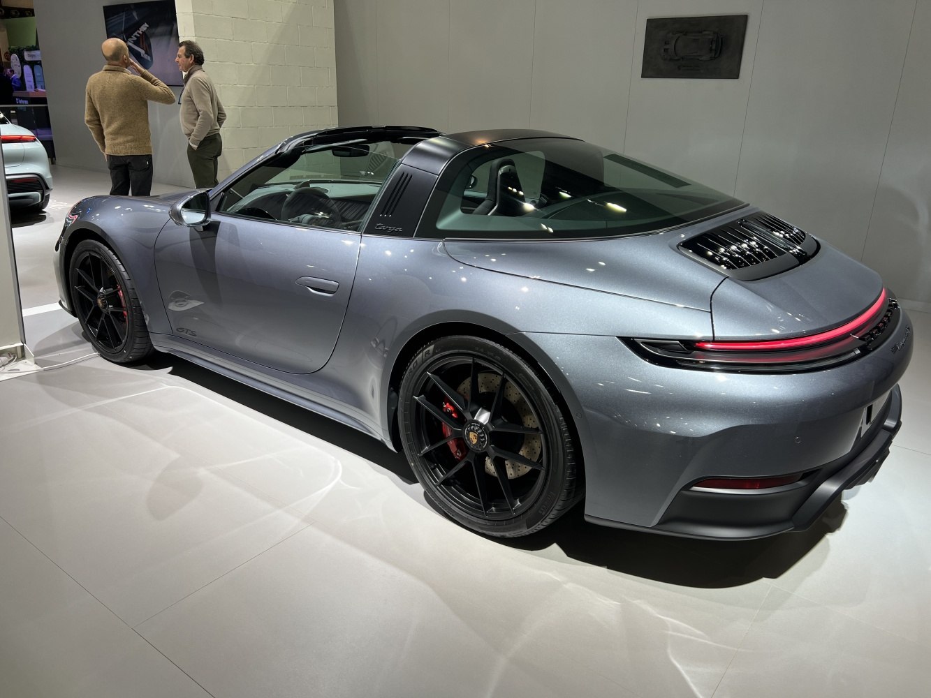 Rear side profile of a silver sports coupe with LED tail light bar and black wheels