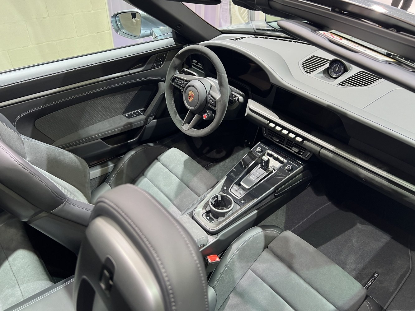 Alcantara steering wheel and sleek center console in a modern sports car interior