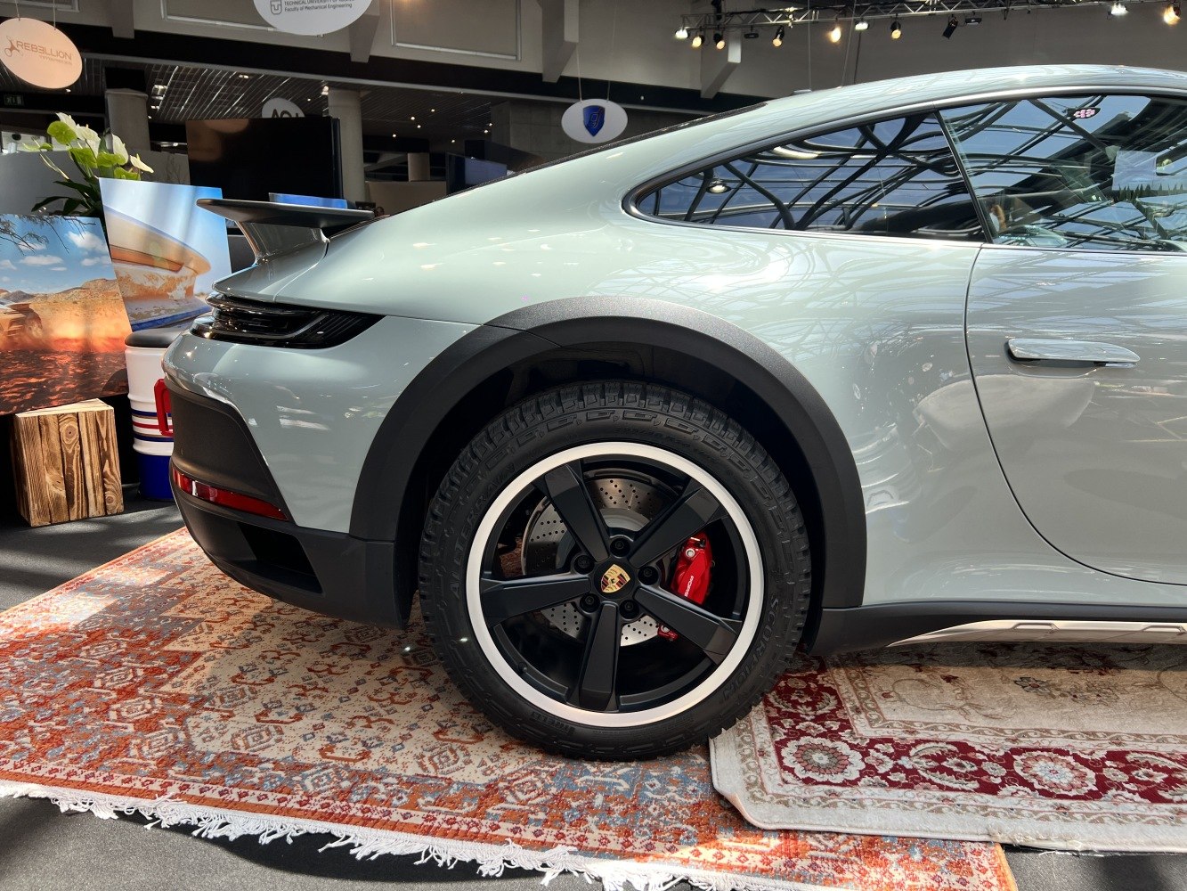 Rear wheel, black rim, red brake caliper, and rear spoiler detail