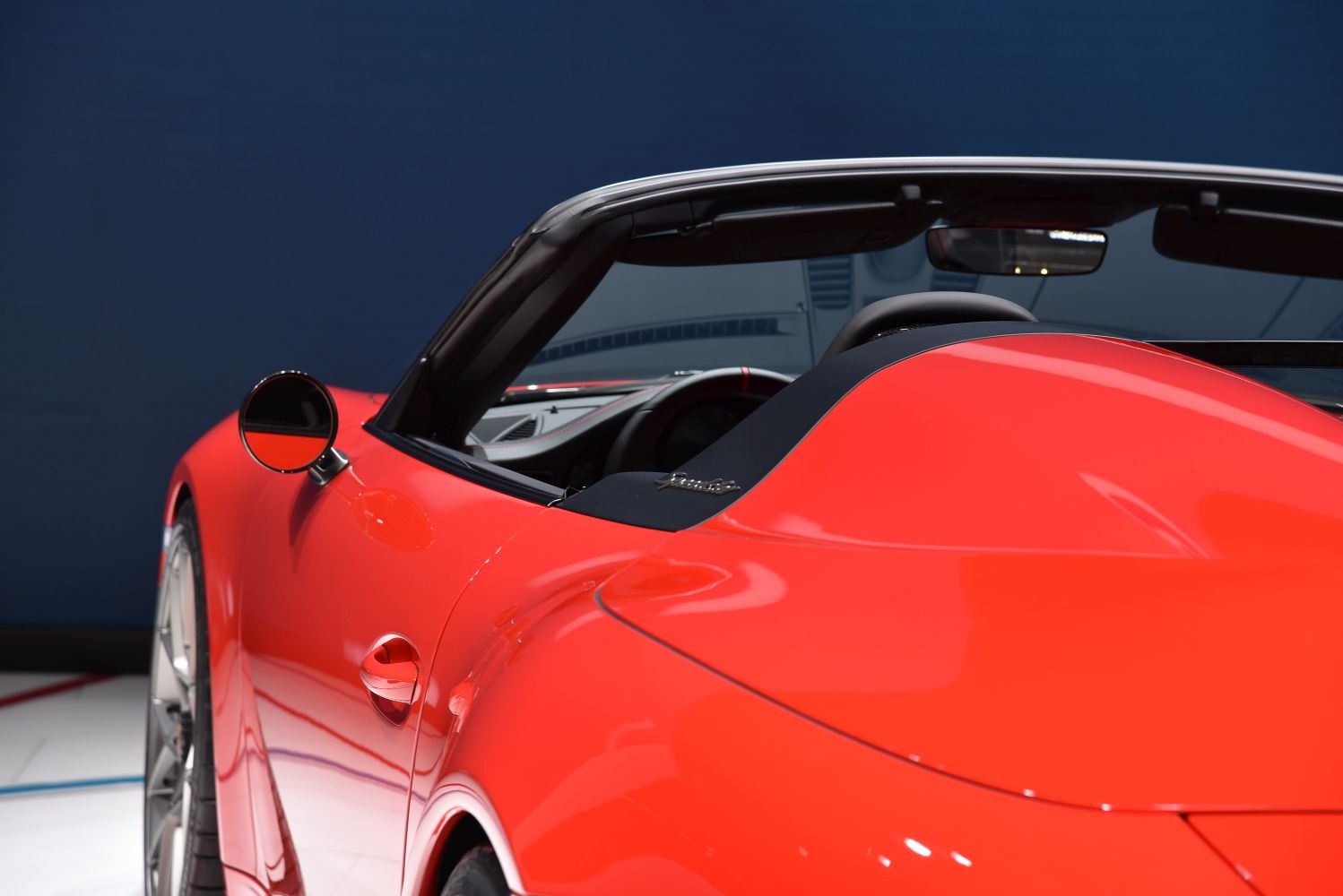 Red convertible sports car rear side close-up with dashboard interior visible