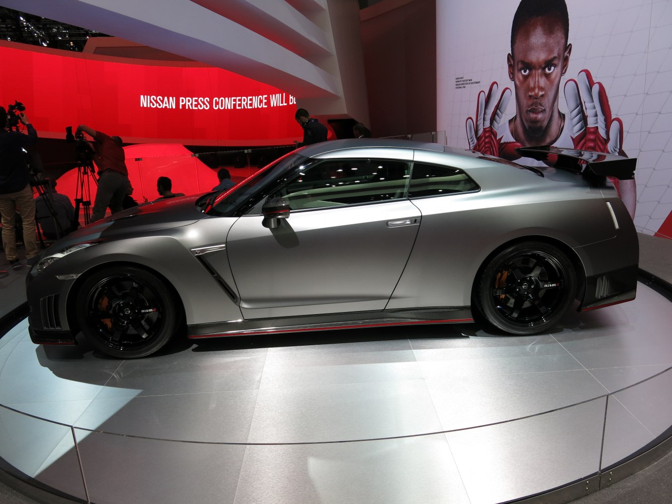 Silver sports coupe side view with black NISMO wheels and rear spoiler